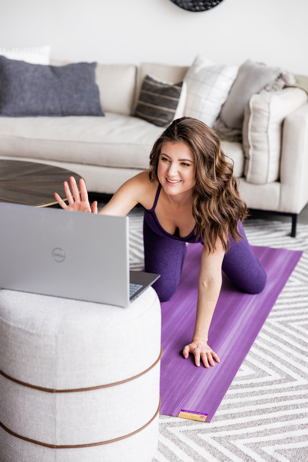 Adriane waves hello to computer for online yoga class